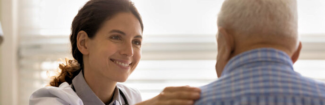 Doctor supporting older person with hand on shoulder